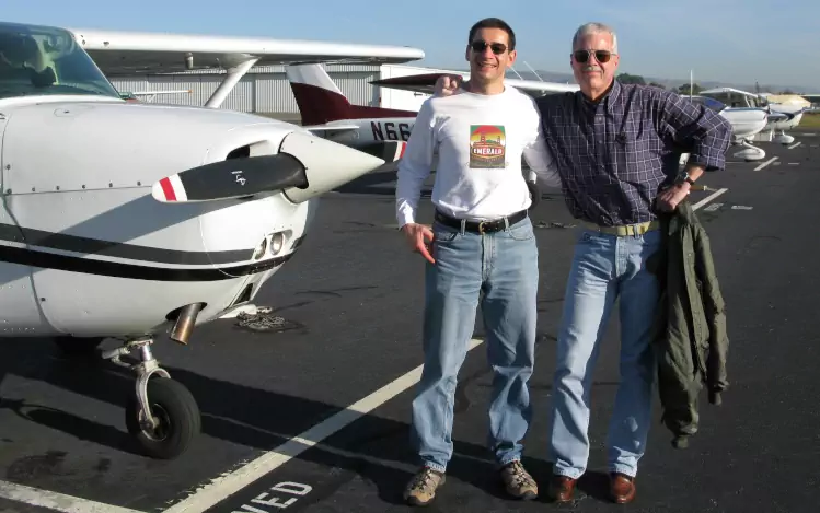 Darius and flying instructor in front of a row of parked Cessnas